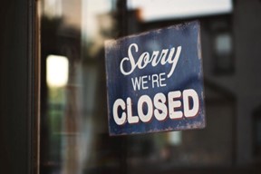 Photo of a sorry were closed sign hanging in a window